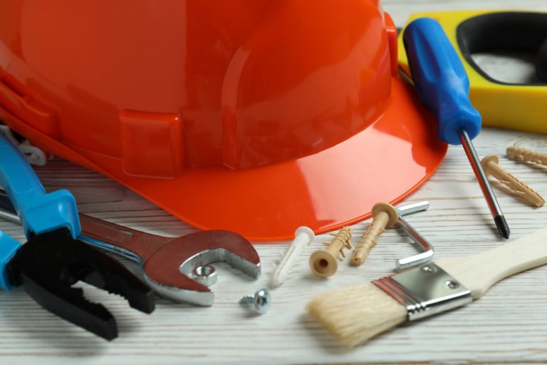 Concept of Labor Day with different construction tools on white wooden background